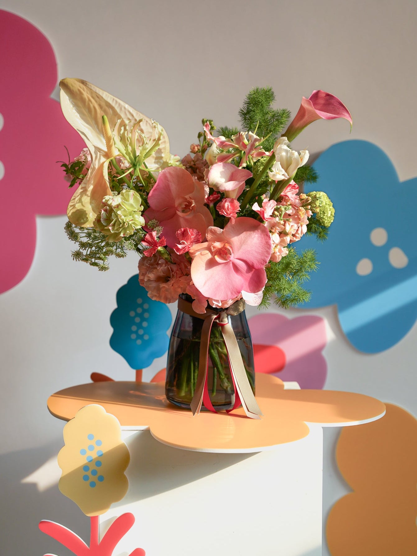 Studio Ode colorful Bouquet of mother's day flowers in a vase on a floral-patterned| size: In a Vase - 28cm